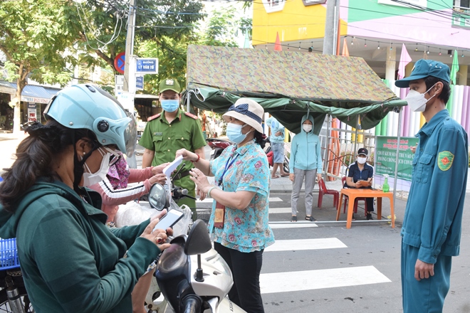 The functional forces of Phuoc My Ward, Son Tra District checks travel passes shown by road users at a quarantine checkpoint on Ly Van To Street. Photo: HOANG HIEP