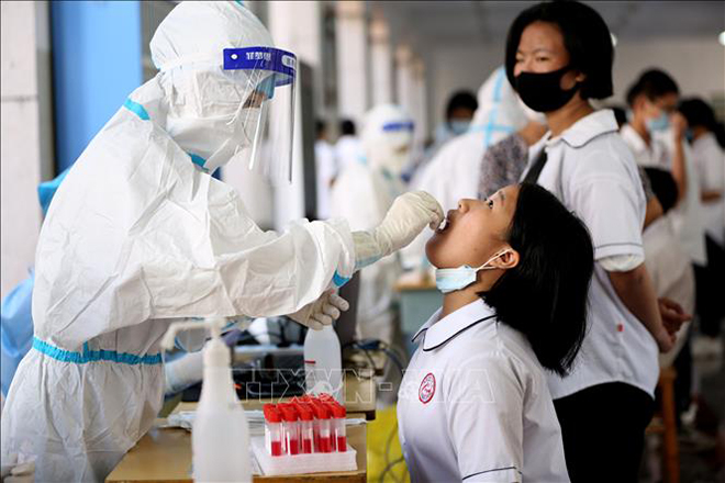 Nhân viên y tế lấy mẫu xét nghiệm Covid-19 tại một trường học ở tỉnh Phúc Kiến, Trung Quốc, ngày 15-9-2021. Ảnh: THX/TTXVN