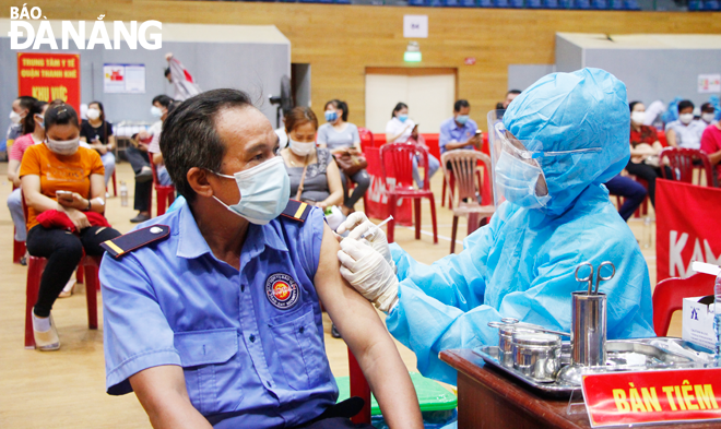 A Da Nang medical staffer administers COVID-19 vaccine to a corporate worker at the Tien Son Sports Arena. Photo: Xuan Dung
