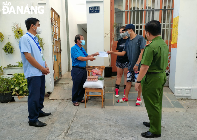 Representatives from My An Ward authorities visiting and giving food support to foreigners. Photo: TRUNG HUY