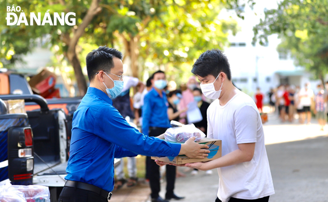 Nguyen Manh Dung (left), Secretary of Da Nang Youth Union, presents gifts to students facing difficulties due to the impact of COVID-19. Photo: T.V