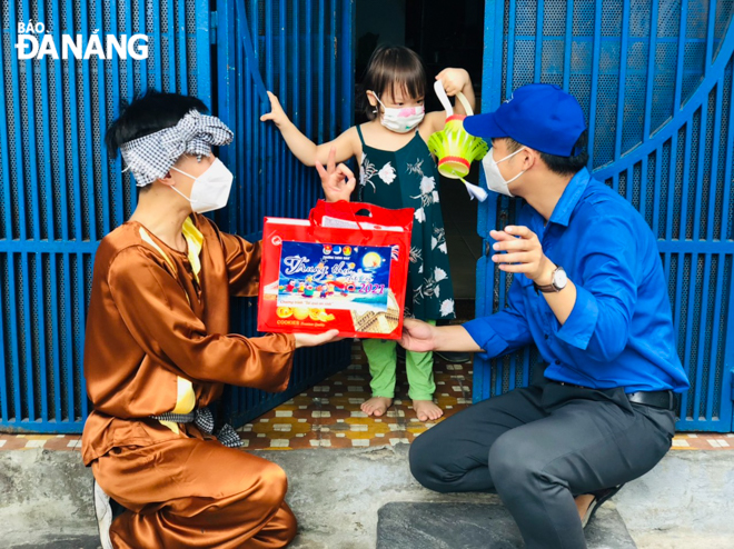 Acting as ‘Chu Cuoi’ (Moon boy), Vo Xuan Than, a Youth Union member in Chinh Gian Ward, Thanh Khe District (left ) is one of the 15 delivery men, locally known as ‘shippers’, who task themselves with giving gifts to 130 disadvantaged children in the ward.