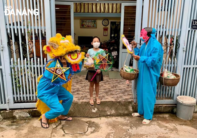  Wearing a protective costume with a lion's head, a local volunteer group’s members present gifts and perform lion dance for children living in alley No. 135 Ton Dan street, Hoa An Ward, Cam Le District.