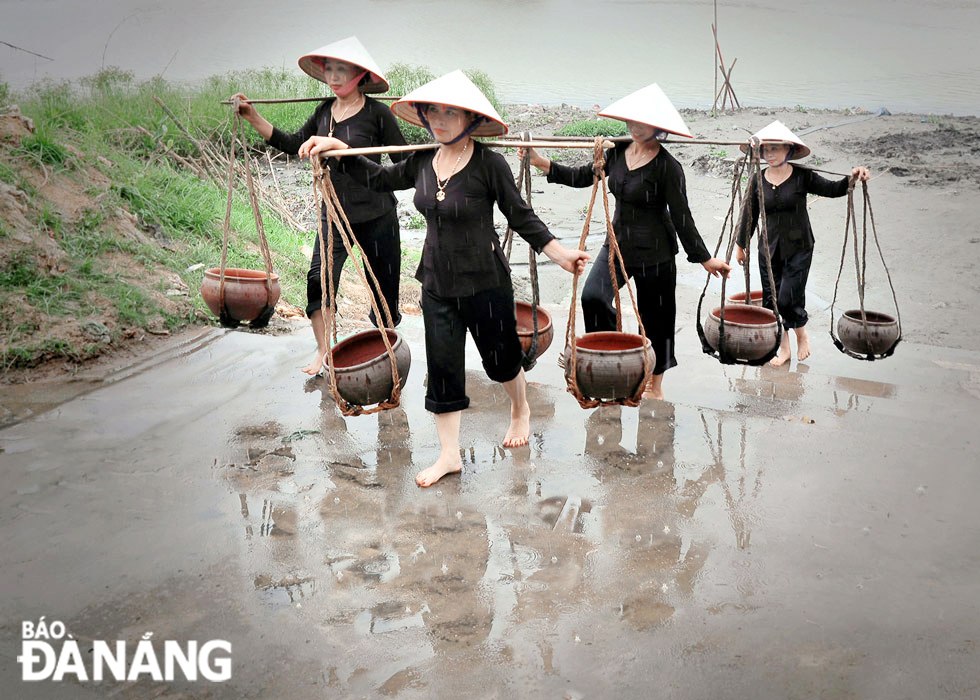 A group of women in the village are assigned to carry water from the Duong River to pour it into the playing field.