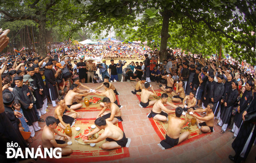 Ahead of the competition, each man drinks 3 bowls of wine and eats watermelon at the communal house yard.