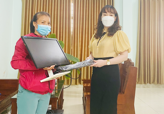 Ms Nguyen Tran Le Hong Trinh (right), Principal of Vo Thi Sau Primary School presents a computer to a student having difficult circumstances. (Photo courtesy of  Lien Chieu District chapter of Education and Training Department)