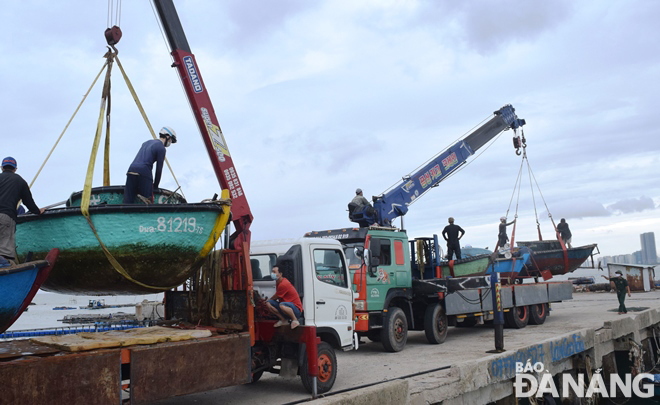 Ngư dân khẩn trương đưa thuyền, thúng máy lên bờ tại cảng CT.15. Ảnh: HOÀNG HIỆP