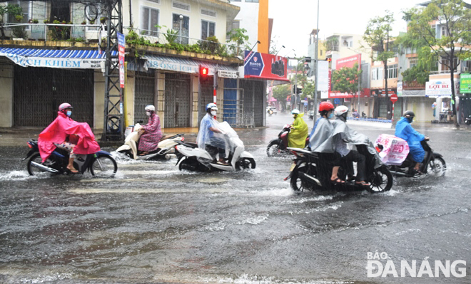 Heavy rains flood an area at the intersection of Ong Ich Khiem - Le Duan streets in the noon hours on September 23. Photo: HOANG HIEP