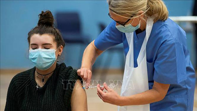 Nhân viên y tế Anh tiêm vaccine Covid-19 cho người dân tại trung tâm tiêm chủng di động ở phía Bắc London, ngày 25-6-2021. Ảnh: AFP/TTXVN