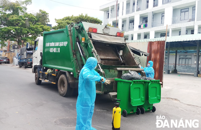 Công nhân Xí nghiệp Môi trường Sơn Trà thu gom rác tại một điểm cách ly trên địa bàn.  Ảnh: NHẬT HẠ	