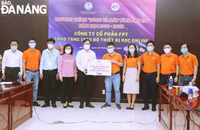 The representatives of the FPT Corporation presents the symbolic board for the donation of 1,000 devices for online learning to needy Da Nang pupils, September 23, 2021. Photo: NGOC HA