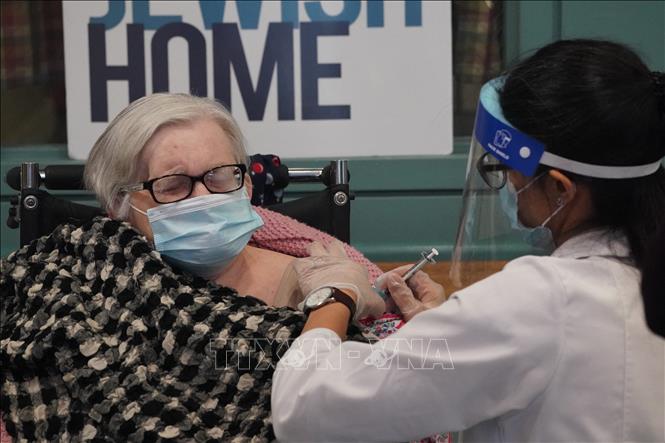 Nhân viên y tế tiêm vaccine Covid-19 của hãng Pfizer cho người cao tuổi tại New York, Mỹ. Ảnh: AFP/TTXVN