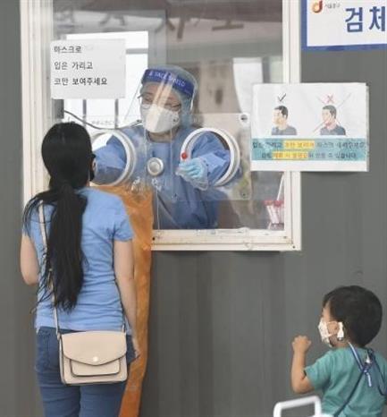 Nhân viên y tế lấy mẫu xét nghiệm COVID-19 cho người dân tại Seoul, Hàn Quốc ngày 25/9/2021. Ảnh: Kyodo/TTXVN