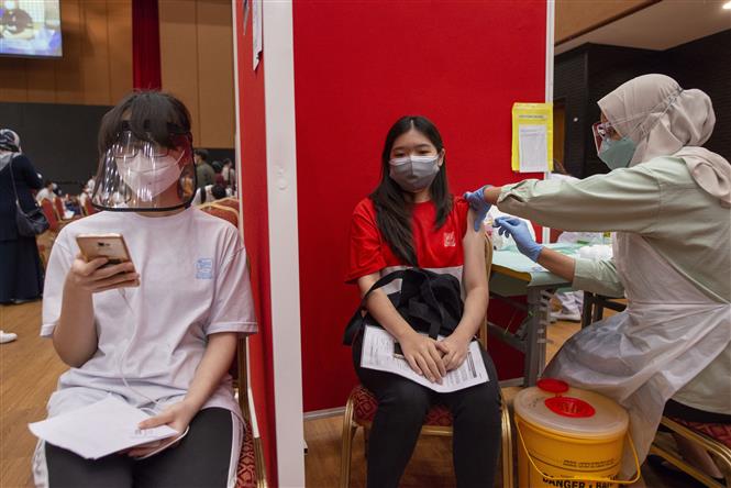 Nhân viên y tế tiêm vaccine ngừa COVID-19 cho học sinh tại Shah Alam, bang Selangor, Malaysia. Ảnh: THX/TTXVN