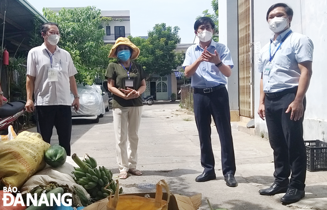 Lãnh đạo quận Sơn Trà kiểm tra việc phân phối rau xanh, củ quả do các đơn vị hỗ trợ miễn phí cho người dân thông qua Ủy ban MTTQ Việt Nam quận.Ảnh: ĐẮC MẠNH	