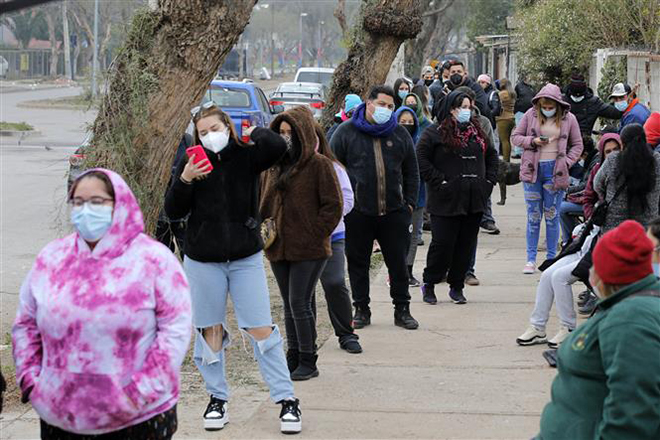 Người dân xếp hàng chờ tiêm vaccine phòng Covid-19 tại Santiago, Chile, ngày 12/7/2021. Ảnh: AFP/ TTXVN