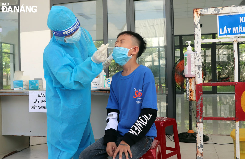 Lực lượng y tế làm xét nghiệm cho học sinh từ Quảng Nam về Đà Nẵng tại chốt C10 đường Trần Đại Nghĩa, quận Ngũ Hành Sơn.