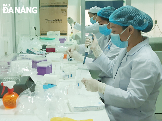 Staff from Da Nang Center for Disease Control analyze nasal swab samples to test for the SARS-CoV-2 virus.