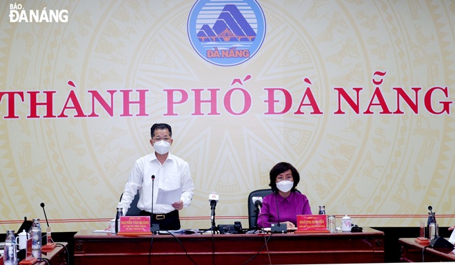 Municipal Party Committee Secretary Nguyen Van Quang (left) announces to lift more restrictions from September 30 on a regular meeting with member of the municipal COVID-19 Monitoring Committee on Tuesday afternoon. Photo: PHAN CHUNG