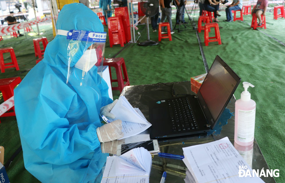  Medical staff prepare mandatory declaration forms which must be filled out by the returnees from northern localities and the central province of Thua Thien- Hue Province at a checkpoint on Ta Quang Buu Street, Lien Chieu District.