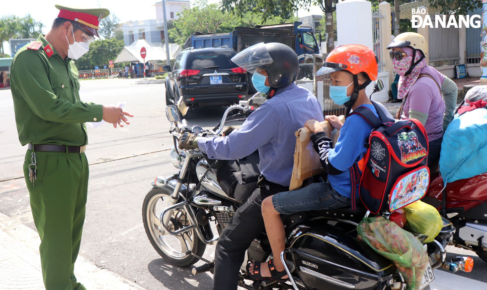 After obtaining negative test results, the returnees have their administrative papers checked by functional forces for the last time. Photo taken at a checkpoint on Tran Dai Nghia Street, Ngu Hanh Son District.