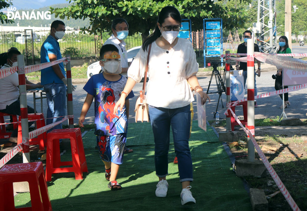 Phụ huynh và học sinh tại khu kiểm tra y tế tại chốt C1 đường Tạ Quang Bửu, quận Liên Chiểu. Ảnh: NGỌC HÀ.