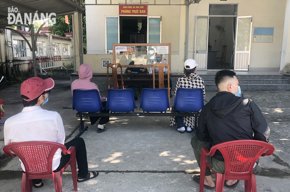 In Hoa Son Commune, Hoa Vang District, the handling of administrative procedures is implemented closely and seriously. Before entering the ‘one-stop-shop’ site here, citizens must have their body temperatures checked and make medical declarations. Photo: NGUYEN QUANG