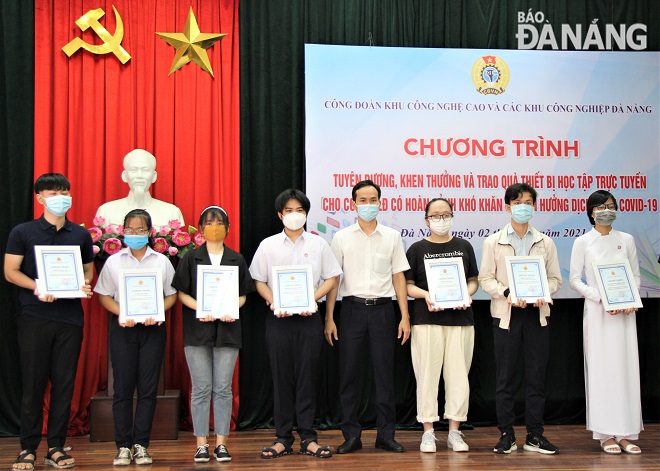 Chủ tịch Liên đoàn Lao động thành phố Nguyễn Duy Minh (thứ 4, phải sang) trao học bổng cho các em học sinh có thành tích xuất sắc trong năm học 2020-2021. Ảnh: L.P