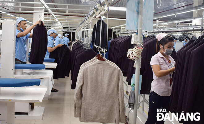 Workers of the Hoa Tho Textile and Garment Corporation are checking the quality of vestons for export. Photo: KHANH HOA