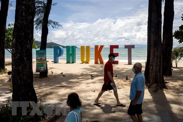  Tourists walk on the beach in Phuket, Thailand, on August 14. (Photo: AFP/VNA)