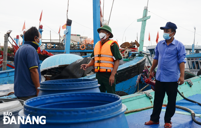Lực lượng chức năng yêu cầu ngư dân ngoại tỉnh ở lại trên tàu cá neo đậu ở âu thuyền Thọ Quang để trú bão số 5 và bảo đảm công tác phòng, chống Covid-19. Ảnh: HOÀNG HIỆP