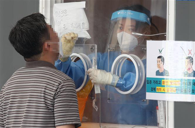  Nhân viên y tế lấy mẫu xét nghiệm Covid-19 tại Seoul, Hàn Quốc, ngày 15-8-2021. Ảnh: YONHAP/TTXVN
