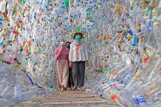 People walk through a tunnel built from plastic bottles collected from several rivers in Indonesia in three years, at the plastic museum constructed by local environmental activists in the town of Gresik, East Java province in September 28, 2021. (Photo: Reuters)