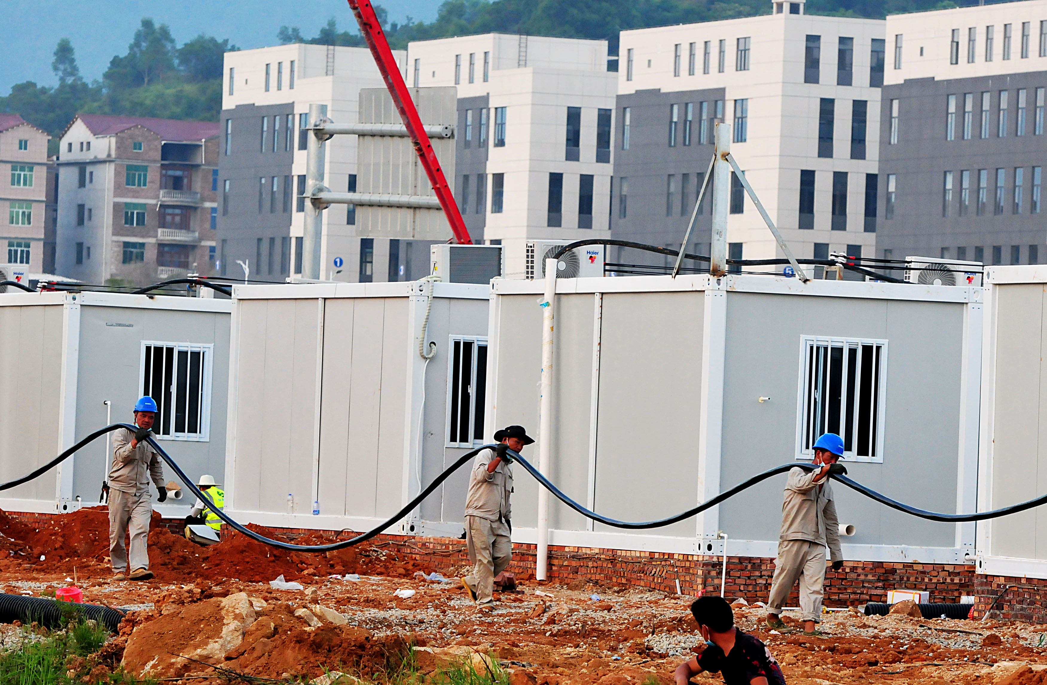 Các công nhân xây dựng một trung tâm cách ly gồm 1.000 phòng ở Phủ Điền, tỉnh Phúc Kiến, Trung Quốc. (Ảnh chụp ngày 27-9-2021) Ảnh: Getty Images	