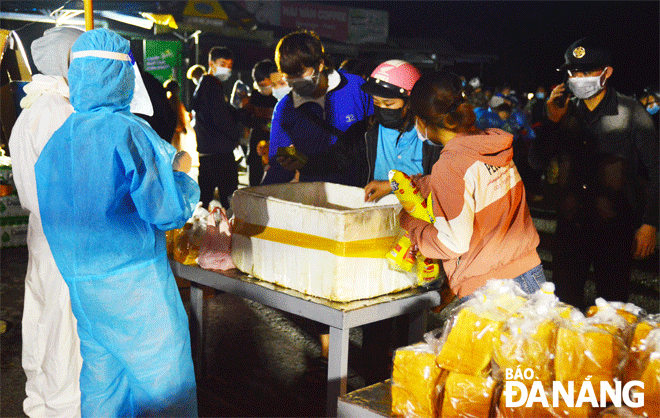 Sữa, bánh mỳ, bánh chưng, nước uống các loại được các đội nhóm thiện nguyện trao tận tay cho người dân về quê qua địa phận Đà Nẵng. Ảnh: XUÂN SƠN