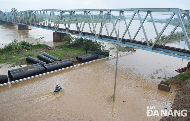 The Cam Le River overflowing its banks, flooding a section of a riverside road. Photo: HOANG HIEP