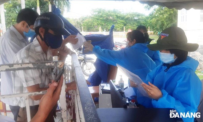 Lực lượng làm nhiệm vụ tại điểm chốt cửa ngõ ra, vào thành phố Đà Nẵng nằm trên tuyến đường Trần Đại Nghĩa (quận Ngũ Hành Sơn) kiểm tra giấy chứng nhận xét nghiệm âm tính với SARS-CoV-2. Ảnh: LÊ HÙNG