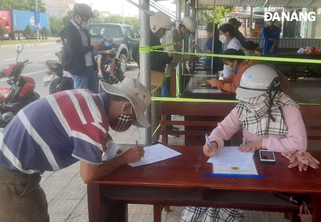 People are seen making mandatory medical declarations to be eligible to enter Quang Nam. Photo: LE HUNG