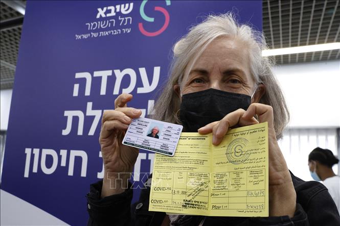 Một người Israel giới thiệu thẻ quốc tế và giấy Chứng nhận tiêm vaccine ngừa Covid-19 tại trung tâm y tế Sheba ở Ramat Gan, gần Tel Aviv, ngày 14/1/2021. Ảnh: AFP/TTXVN