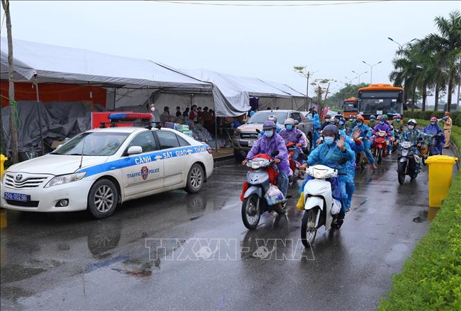 Lực lượng chức năng hỗ trợ người dân di chuyển khỏi điểm trung chuyển huyện Phú Xuyên để tiếp tục hành trình về quê, chiều 9/10. Ảnh minh họa: Hoàng Hiếu/TTXVN