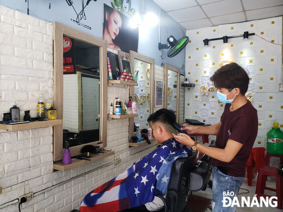 Hair salons are allowed to resume operations provided that their owners and employees have received at least one dose of COVID-19 vaccine and they are not permitted to serve more than 3 people at a time. Photo by XUAN SON