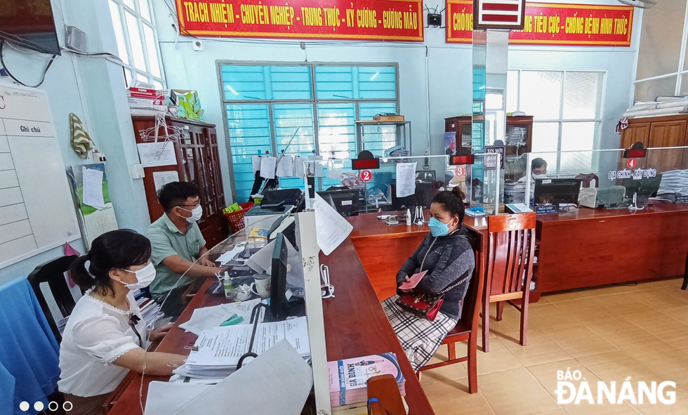 At State administrative agencies at all levels, both employees and visitors are required to wear medical masks and maintain a safe distance from each other. Photo by NGUYEN LE