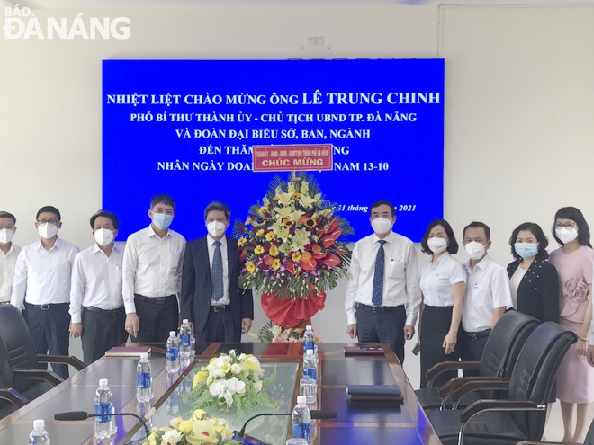 Chủ tịch UBND thành phố Lê Trung Chinh (thứ 5, phải qua) chúc mừng Công ty CP Cao su Đà Nẵng nhân ngày 