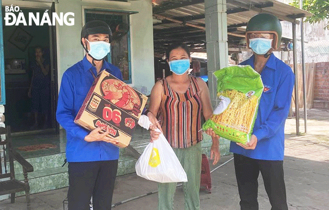 Hai thành viên tổ phản ứng nhanh thôn Nhơn Thọ 2 (xã Hòa Phước) trao hàng cứu trợ tại nhà cho hộ dân có hoàn cảnh khó khăn năm 2021. Ảnh: LÊ VĂN THƠM