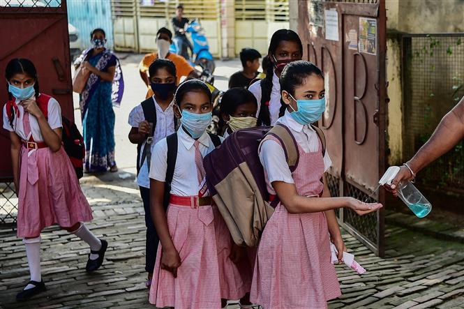 Học sinh đeo khẩu trang, khử khuẩn tay phòng lây nhiễm COVID-19 tại trường học ở Allahabad , Ấn Độ, ngày 1/9/2021. Ảnh: THX/TTXVN