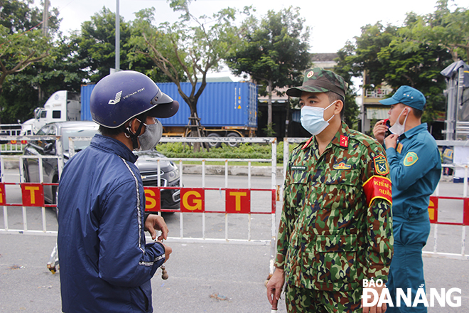 Lực lượng chức năng hướng dẫn người dân làm thủ tục vào Đà Nẵng, Ảnh: XUÂN DŨNG