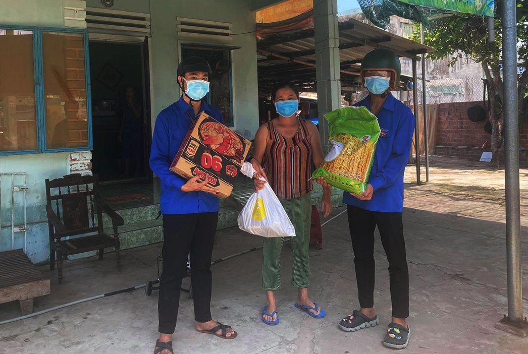 Two Youth Union members delivering relief goods to poor families 