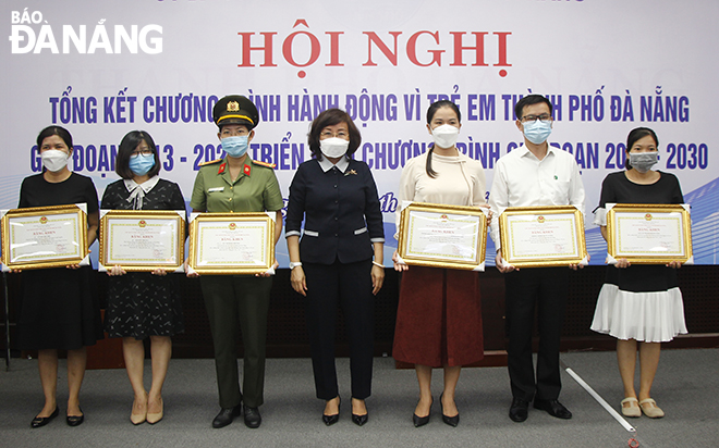 Da Nang Vice Chairwoman People's Committee Ngo Thi Kim Yen (centre) presents certificates of merit from the municipal People's Committee to 12 collectives and 7 individuals in recognition for their outstanding achievements in action for children in the 2013 - 2020 period, October 14, 2021. Photo: XUAN DUNG