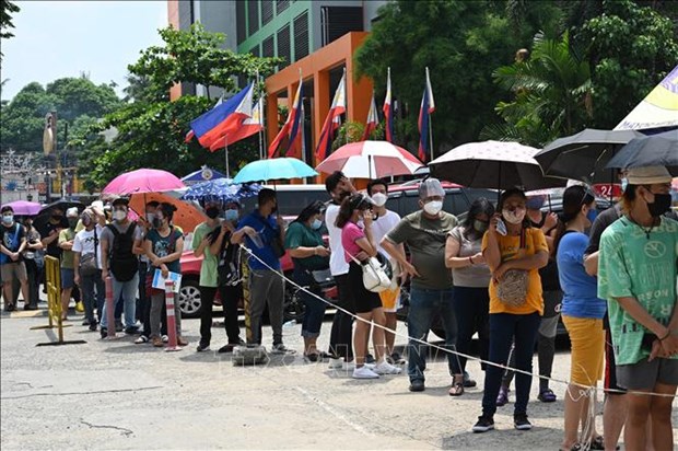 People waiting in line to get vaccinated against COVID-19 in Manila, Philippines. (Photo: AFP/VNA)