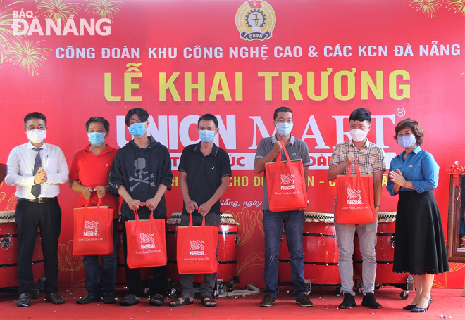  Vice Chairman of the Da Nang Labour Union Dinh Thi Thanh Ha (first, right) and a representative of Lien Chieu District authority (first, left) give gifts to workers in difficult circumstances.